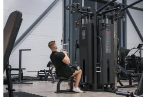 En stark man gör latsdrag i en kabelmaskin från Thor Fitness