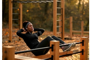En kvinna gör situps i ett utegym på hösten