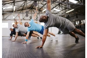 En träningsgrupp på ett gym gör sidoplankan tillsammans