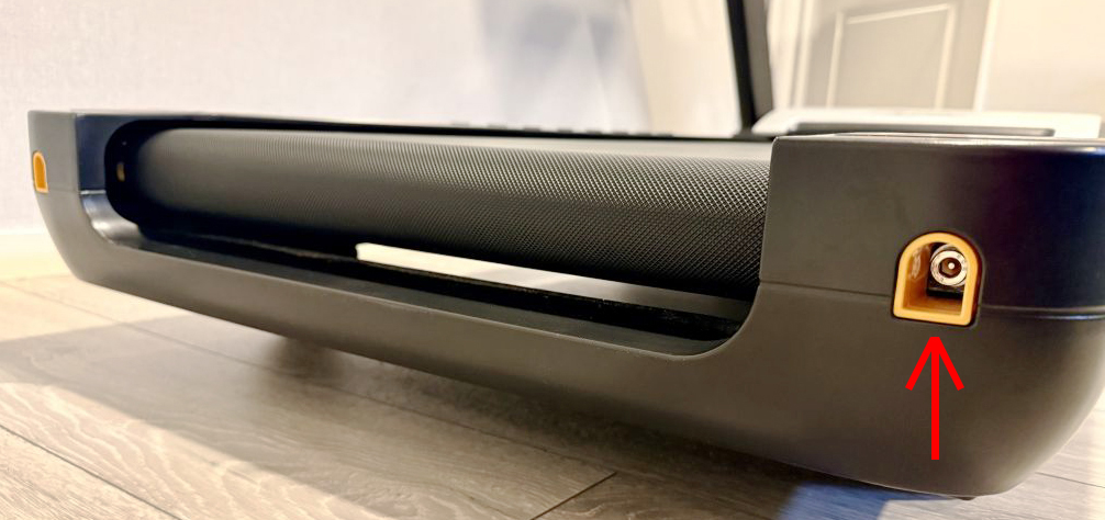 Baksida på löpband med tydliga justerskruvar på varje sida